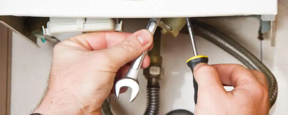 Boiler repair technician tightening pipe fittings and connections in Fort Worth, TX