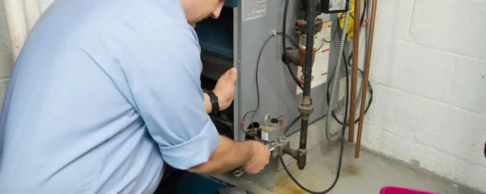 Furnace repair technician inspecting and servicing a home heating system in Fort Worth, TX