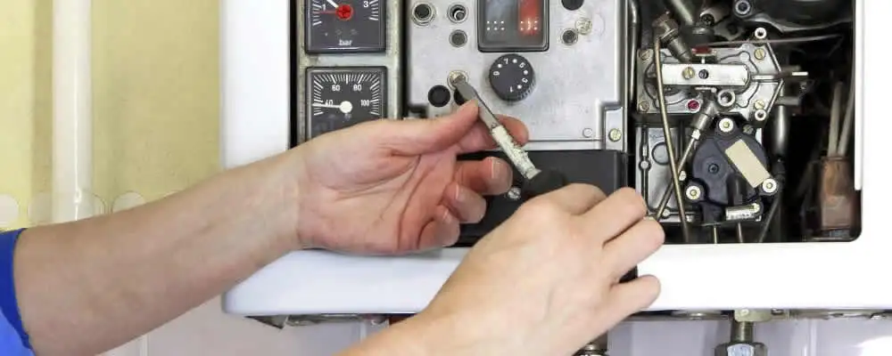 Heating repair technician adjusting boiler controls and components in Fort Worth, TX