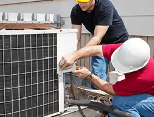 HVAC technicians repairing an outdoor AC unit on a rooftop in Fort Worth, TX