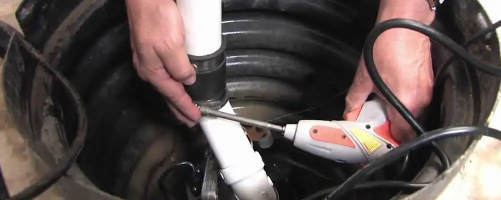 Sump pump installation technician connecting PVC discharge piping in Fort Worth, TX