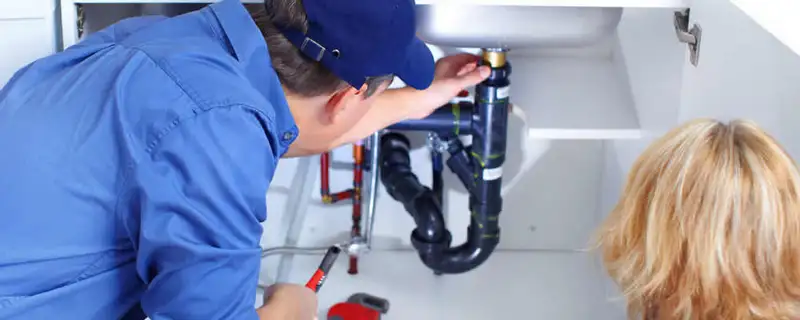 Plumber repairing under-sink drain pipes and fittings in Fort Worth, TX
